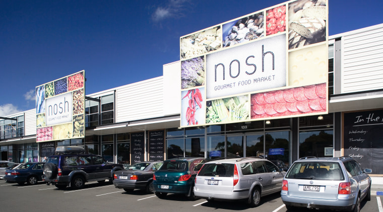 A view of this block of retail premises advertising, billboard, building, car, city, compact car, downtown, family car, luxury vehicle, real estate, sedan, signage, vehicle, blue, white