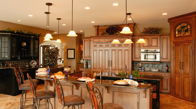 View of this kitchen featuring colonial style tomber cabinetry, ceiling, countertop, cuisine classique, dining room, flooring, interior design, kitchen, room, wood, orange, brown