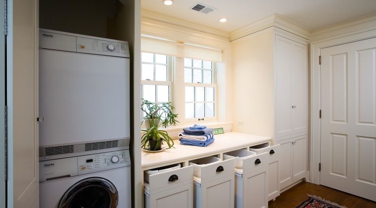A view of this laundry featuring white timber cabinetry, clothes dryer, countertop, floor, home, home appliance, kitchen, laundry, laundry room, major appliance, room, washing machine, gray