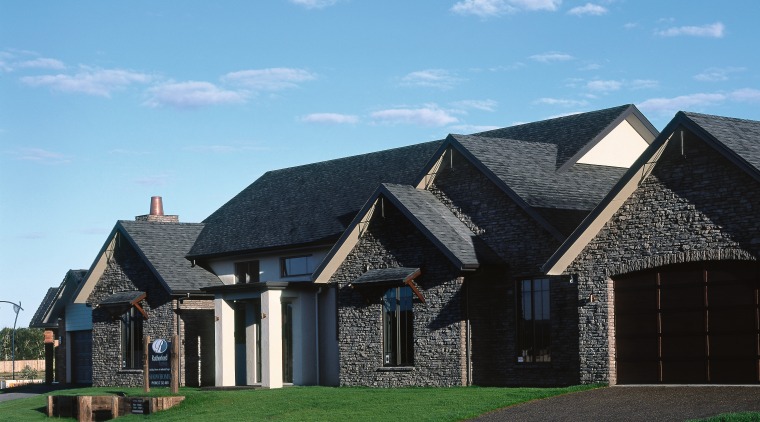 A view of this Rutherford Homes show home building, cottage, elevation, estate, facade, farmhouse, home, house, property, real estate, residential area, roof, siding, sky, suburb, teal, black