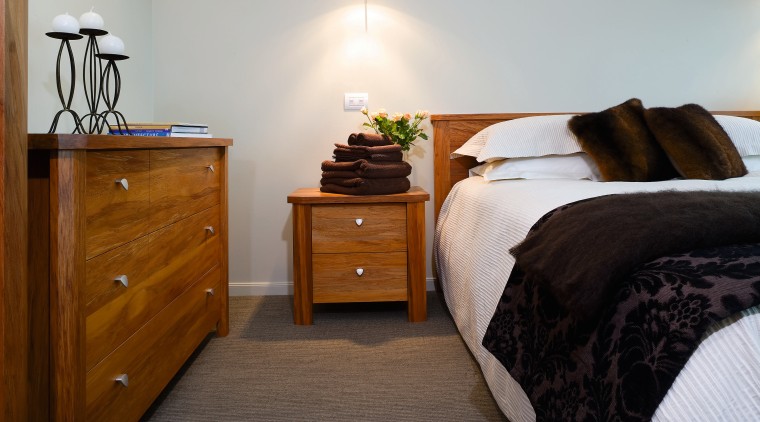 A view of some furniture from East West bed, bed frame, bedroom, chest of drawers, drawer, floor, flooring, furniture, hardwood, home, interior design, nightstand, property, room, suite, wood, gray, brown