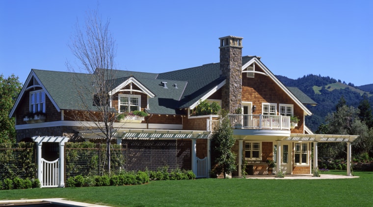 An exterior view of this traditional masonry home cottage, elevation, estate, facade, farmhouse, home, house, mansion, property, real estate, residential area, roof, siding, villa, blue