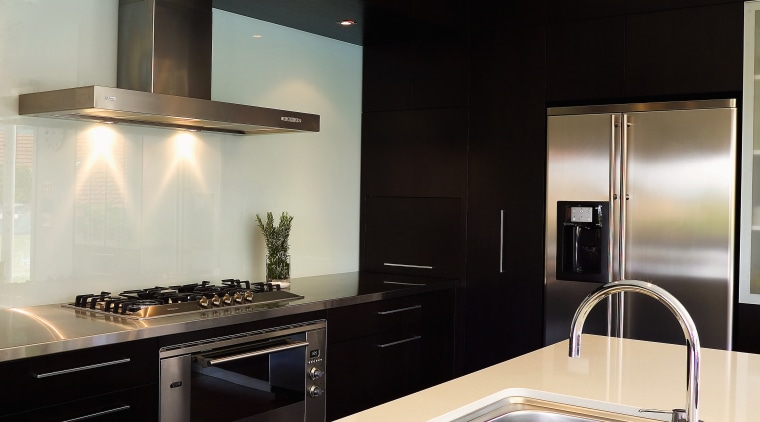 A view of athis kitchen featuring mahogany and countertop, interior design, kitchen, room, sink, white, black