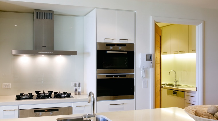 A view of this kitchen apartment featuring white cabinetry, countertop, cuisine classique, interior design, kitchen, room, gray