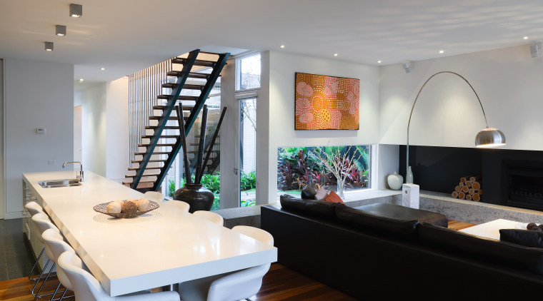 The open stairway adds a strong graphic element ceiling, interior design, living room, room, table, gray