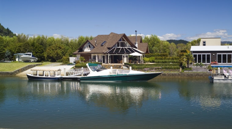 View of new canal-front properties by Hopper Developments. boat, cottage, estate, home, house, lake, marina, property, real estate, reflection, resort, sky, tree, villa, water, waterway, teal