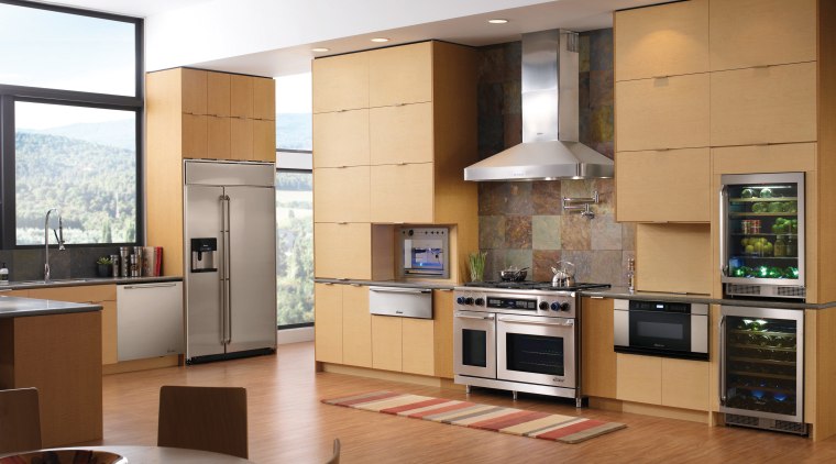 A view of this kitchen featuring the latest cabinetry, countertop, cuisine classique, floor, flooring, hardwood, home appliance, interior design, kitchen, living room, room, wood flooring, brown, gray