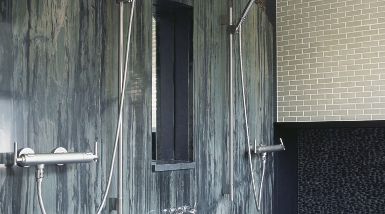 A bamboo-pattern granite forms a feature wall. The bathroom, interior design, plumbing fixture, room, wall, window, gray, black