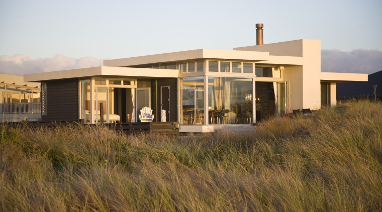 A solid central wall grounds this beach house, architecture, facade, home, house, property, real estate, residential area, sky, brown, white