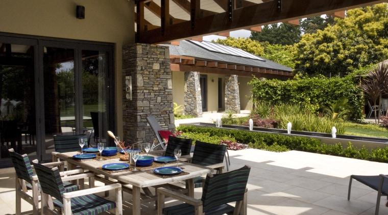 View of the patio area which features outdoor backyard, courtyard, outdoor structure, patio, table, brown, black