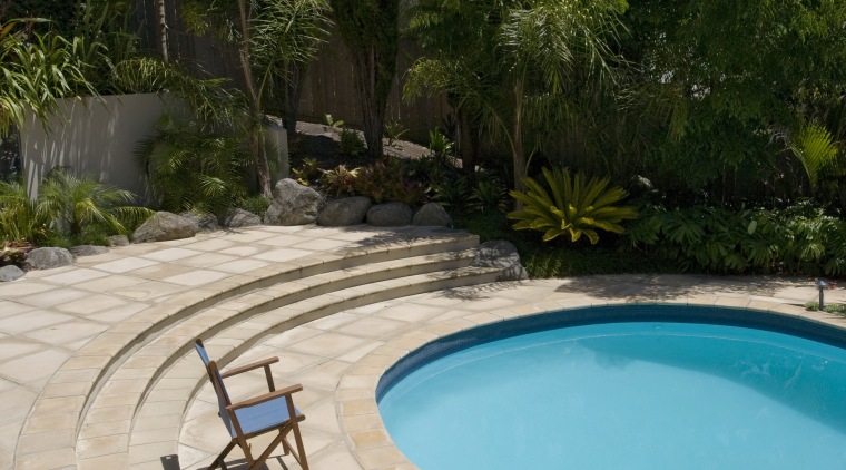 View of a pool with paving that features backyard, estate, landscape, leisure, outdoor structure, property, real estate, swimming pool, tree, vacation, water, gray