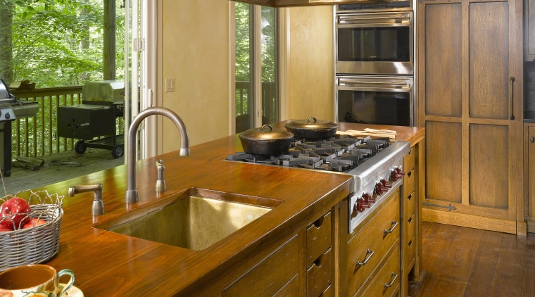 View of a kitchen which features an island cabinetry, countertop, cuisine classique, hardwood, home, interior design, kitchen, real estate, room, brown