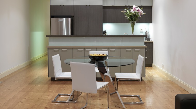 View of minimal kitchen and dining area featuring chair, desk, floor, flooring, furniture, hardwood, interior design, room, table, wood, wood flooring, gray