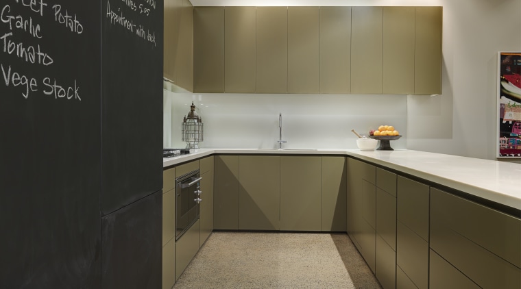 View of kitchen which features large blackboards, polished cabinetry, countertop, floor, flooring, interior design, kitchen, real estate, room, gray, brown