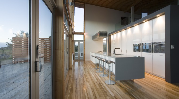 View of a kitchen designed by NKBA designer apartment, architecture, daylighting, floor, flooring, hardwood, house, interior design, loft, real estate, wood, wood flooring, brown