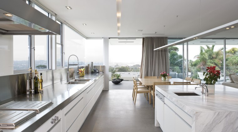 View of the kitchen area which features an architecture, countertop, house, interior design, kitchen, real estate, window, white, gray