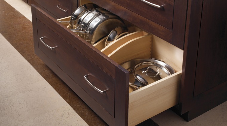 This kitchen features compartmentalized storage solutions.This kitchen features cabinetry, countertop, drawer, furniture, hardwood, kitchen, wood stain, red, brown