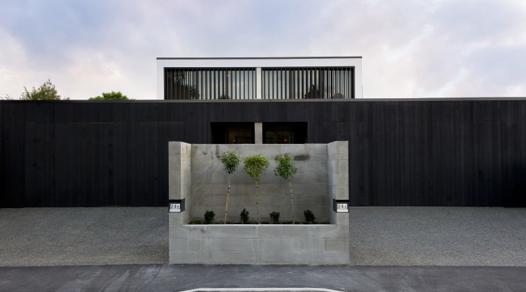 A concrete planter marks the beginning of an architecture, building, facade, home, house, luxury vehicle, property, real estate, residential area, black, white, gray