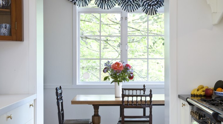 View of dining room through kitchen showing existing cabinetry, chair, dining room, door, floor, furniture, hardwood, home, house, interior design, kitchen, living room, room, shelf, shelving, table, wall, window, window covering, window treatment, wood, gray