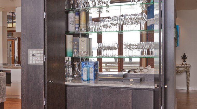 View of open-plan kitchen featuring large cabinet block cabinetry, display case, furniture, glass, interior design, brown
