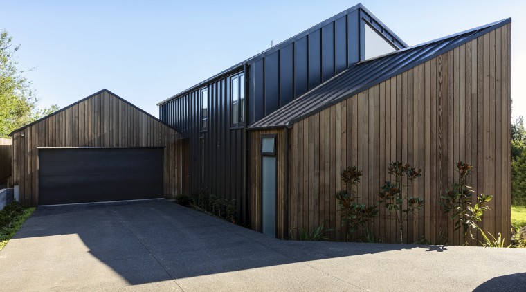 By strategic positioning of the core of the architecture, barn, building, door, facade, garage, home, house, land lot, property, real estate, residential area, roof, shed, siding, tree, black, teal