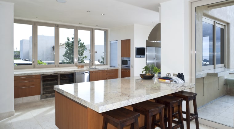 View of kitchen which features island, bar stools, cabinetry, countertop, cuisine classique, estate, interior design, kitchen, property, real estate, gray, white