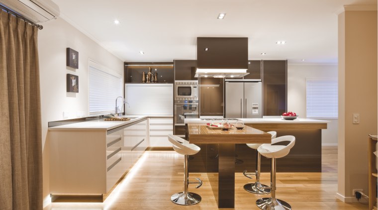 View of a kitchen which features island with cabinetry, countertop, cuisine classique, floor, furniture, interior design, kitchen, office, real estate, room, white, orange