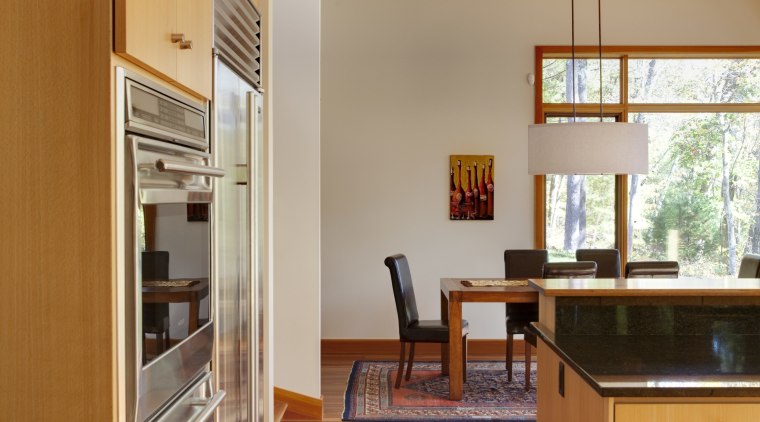 View of sunken open-plan kitchen with wooden cabinetry, architecture, cabinetry, ceiling, countertop, daylighting, floor, flooring, hardwood, house, interior design, kitchen, laminate flooring, real estate, room, wood, wood flooring, brown, orange