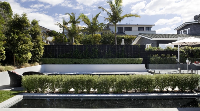 Here is a home designed by Belinda George architecture, backyard, estate, garden, grass, home, house, landscape, landscaping, lawn, luxury vehicle, plant, property, real estate, reflecting pool, residential area, swimming pool, villa, water, white