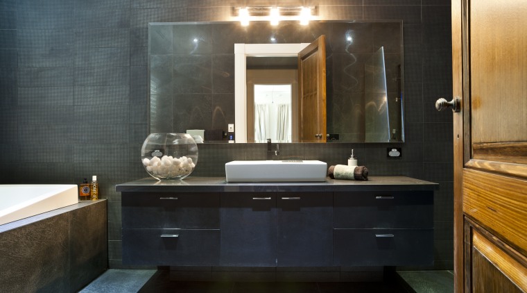 Bathroom with dark grey walls, dark vanity and bathroom, cabinetry, countertop, interior design, room, sink, black