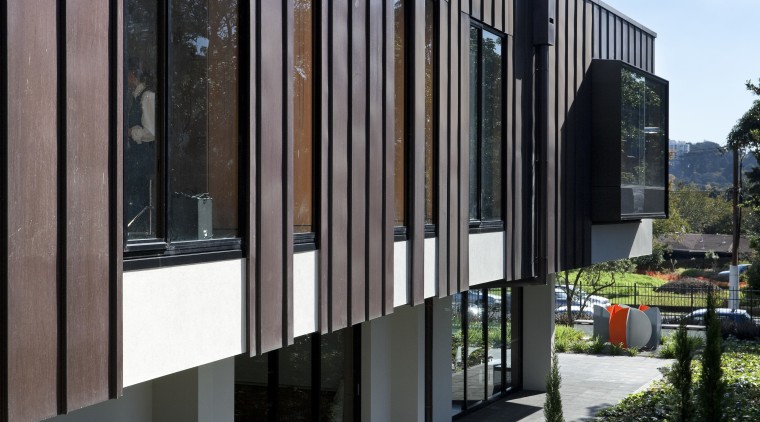 Exterior with red cladding and garden. - Exterior architecture, building, corporate headquarters, facade, home, house, real estate, residential area, black, gray