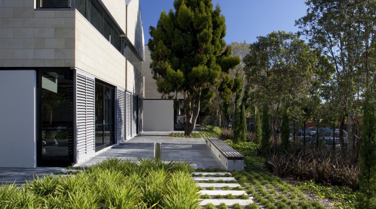 Exterior with landscaping and path. - Exterior with architecture, building, condominium, cottage, estate, facade, home, house, landscape, landscaping, property, real estate, residential area, sky, villa, walkway, blue