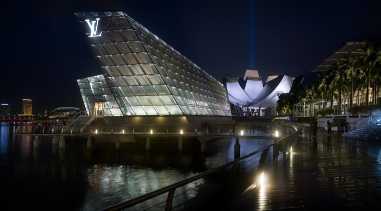 Like the prow of a ship, the illuminated architecture, building, city, cityscape, landmark, light, lighting, metropolis, metropolitan area, night, reflection, sky, structure, tourist attraction, water, black