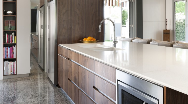 A long peninsula provides ample space for food cabinetry, countertop, cuisine classique, floor, flooring, home appliance, interior design, kitchen, real estate, room, gray