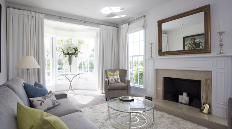 The front living room in this remodeled home ceiling, estate, floor, hearth, home, interior design, living room, property, real estate, room, wall, window, window covering, window treatment, gray