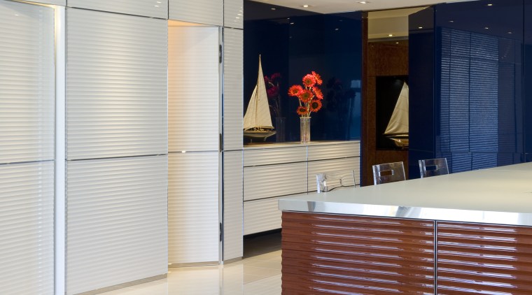 Walls conceal flush doors with touch openings in cabinetry, floor, flooring, furniture, interior design, lobby, room, wall, window blind, window covering, window treatment, gray