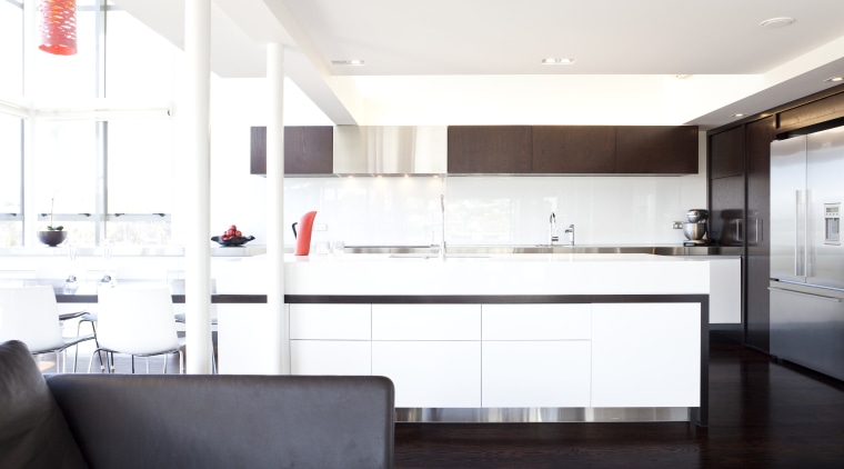 A large island bench extends into a cantilevered countertop, interior design, kitchen, real estate, room, white
