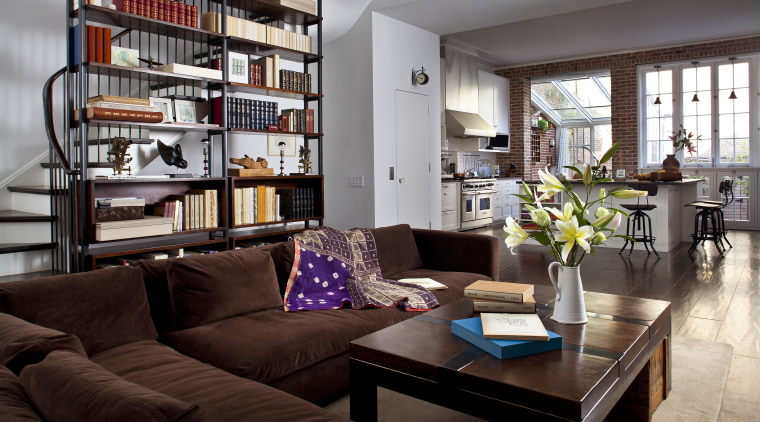 Stairs wind up behind the bookcase in this furniture, home, interior design, living room, room, gray