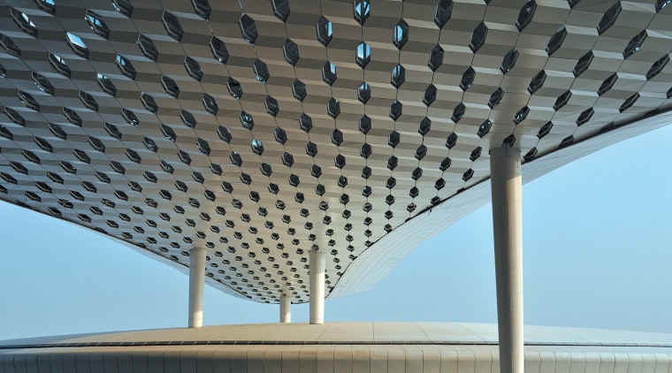 :The terminal features white conical support columns that architecture, building, ceiling, daylighting, infrastructure, line, roof, sky, structure, gray, black