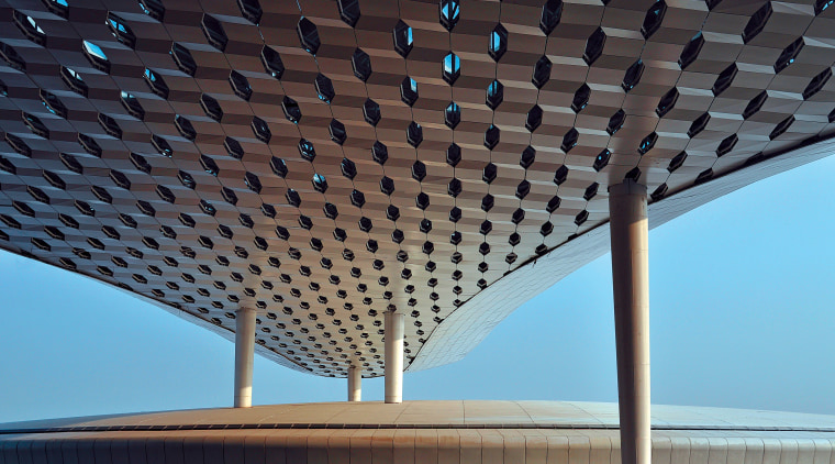 Looking much like a giant sculpture from both architecture, building, ceiling, daylighting, daytime, landmark, line, roof, sky, structure, symmetry, black