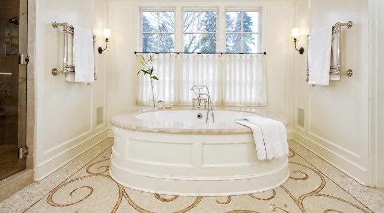 A large round tub with a marble surround bathroom, bathtub, estate, floor, flooring, home, interior design, plumbing fixture, property, real estate, room, tile, wall, window, wood flooring, white