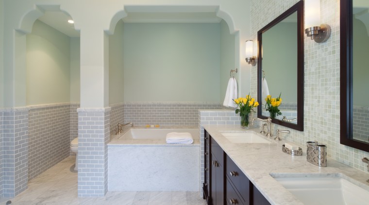 The toilet has its own alcove with an bathroom, bathroom accessory, floor, home, interior design, room, sink, tile, gray