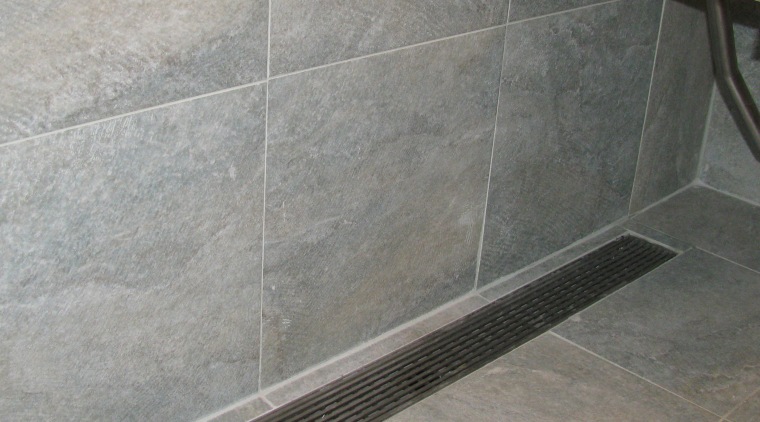 Luxe Linear Drain with a decorative steel grate. floor, flooring, plumbing fixture, tile, gray