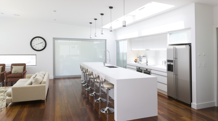 Contemporary white kitchen with large island. Internal sliding floor, flooring, interior design, interior designer, kitchen, living room, real estate, wood flooring, white