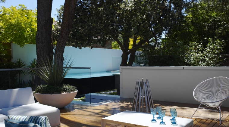 Mature trees provide dappled shade to the patio backyard, furniture, home, house, interior design, outdoor furniture, outdoor structure, patio, plant, swimming pool, table, tree, black
