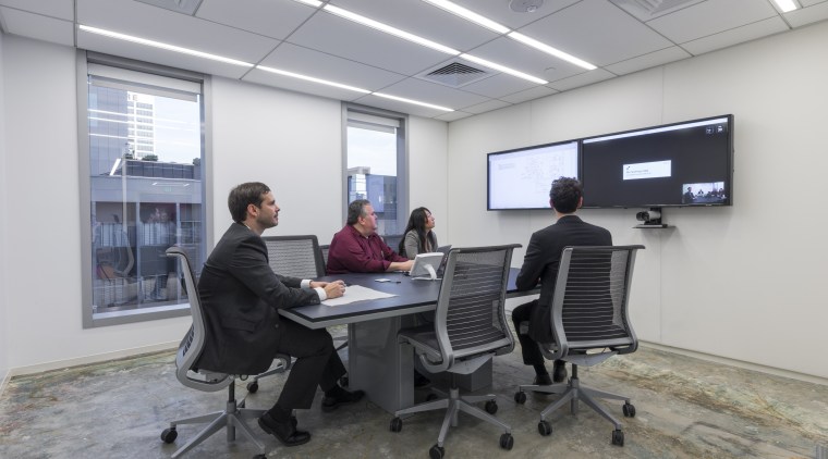 A trapezoidal table in the video-conferencing room of electronic device, institution, office, technology, gray