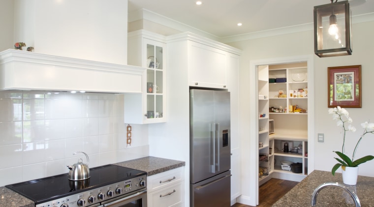 Traditional recessed panel doors and drawers feature on cabinetry, countertop, cuisine classique, floor, home, interior design, kitchen, living room, real estate, room, wood flooring, gray
