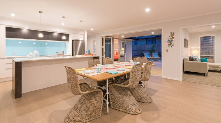 A galley-style kitchen is the social hub of apartment, floor, flooring, hardwood, interior design, living room, property, real estate, room, orange