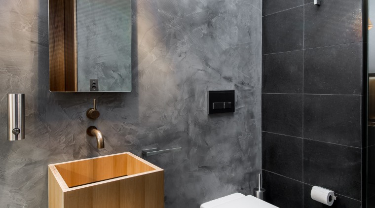 This discreet bathroom by designer Joe Chindarsi is bathroom, bathroom accessory, bathroom cabinet, ceramic, floor, interior design, plumbing fixture, product design, room, sink, tap, tile, wall, gray, black, white