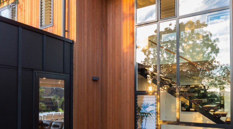 Black and tan black fibrous cement meets red architecture, deck, facade, home, house, interior design, real estate, siding, window, wood, wood stain, brown